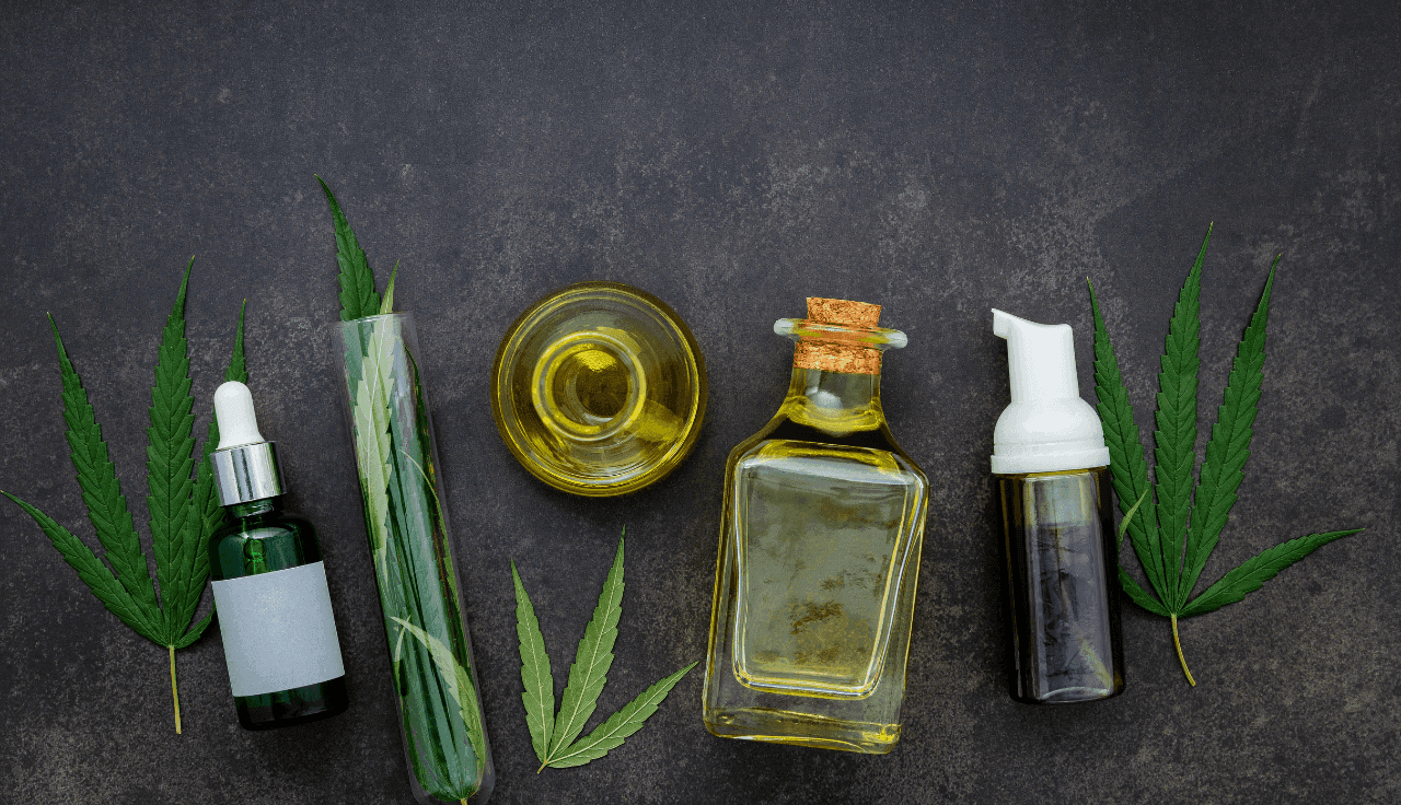 Cannabis Blätter und Öl auf dunkelgrauem Hintergrund